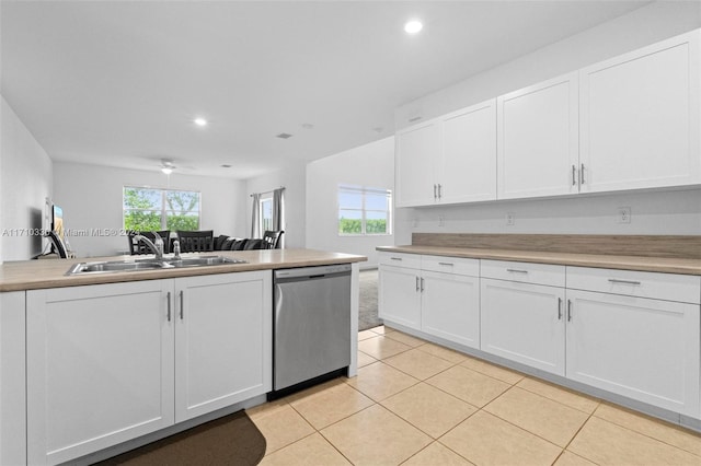 kitchen with white cabinetry, sink, stainless steel dishwasher, and light tile patterned floors