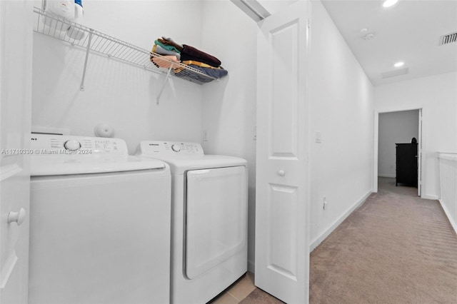 clothes washing area with light carpet and washing machine and clothes dryer