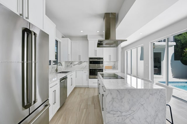 kitchen featuring a center island, white cabinets, sink, island range hood, and stainless steel appliances