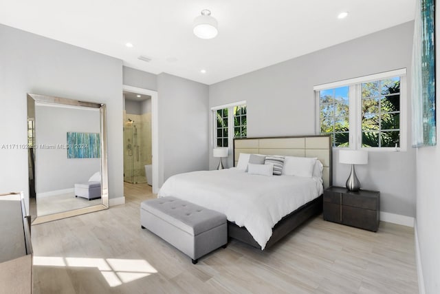 bedroom featuring ensuite bathroom and light hardwood / wood-style floors