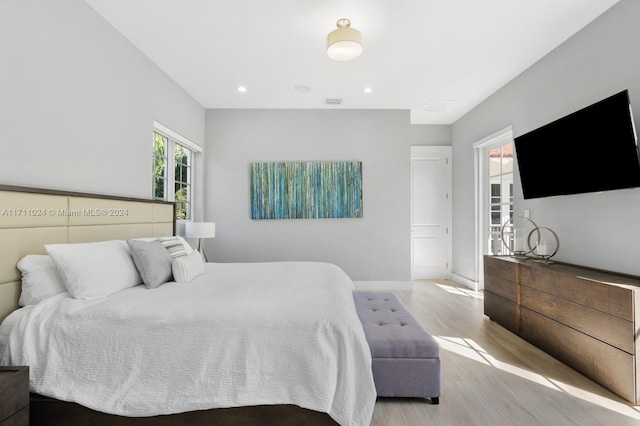 bedroom with light hardwood / wood-style flooring and multiple windows