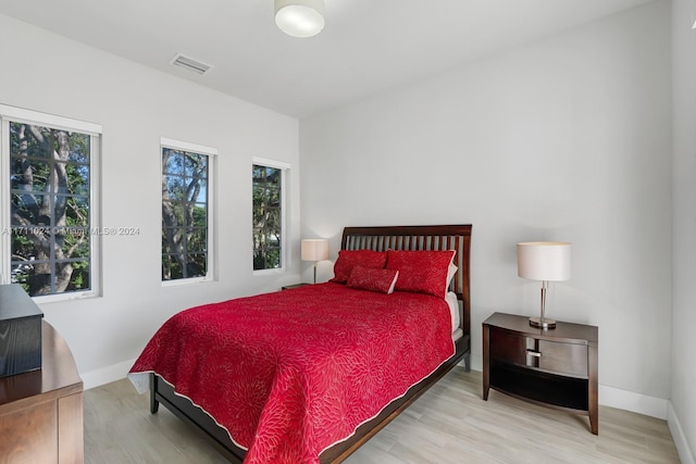 bedroom featuring multiple windows and hardwood / wood-style flooring