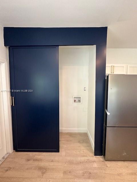 interior details featuring stainless steel fridge and hardwood / wood-style floors