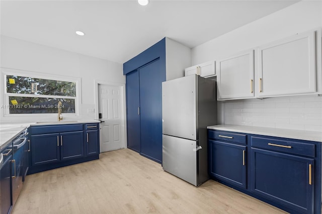 kitchen featuring stainless steel fridge, white cabinetry, blue cabinets, and sink