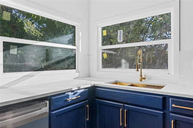 kitchen with dishwasher, blue cabinets, and sink