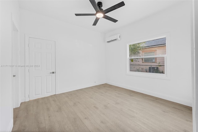 unfurnished room featuring a wall mounted AC, ceiling fan, and light hardwood / wood-style flooring