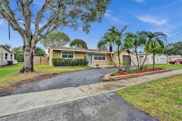 single story home featuring a garage and a front lawn