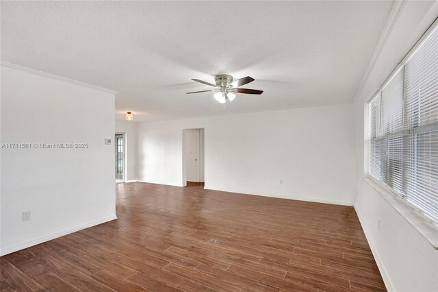 unfurnished room featuring dark hardwood / wood-style floors, a wealth of natural light, crown molding, and ceiling fan