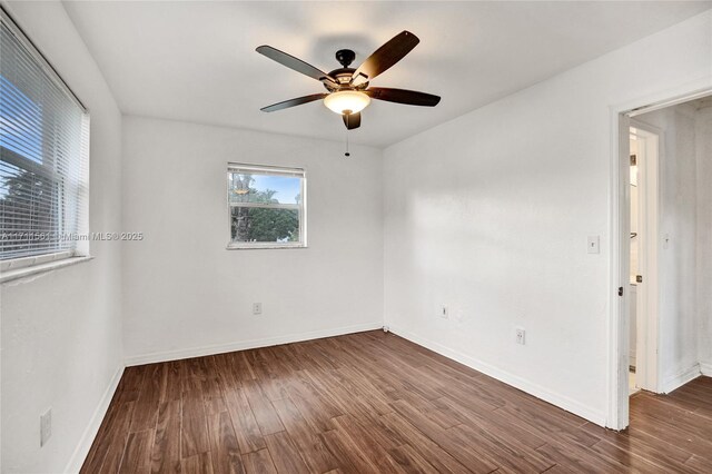 empty room with ceiling fan and dark wood-type flooring