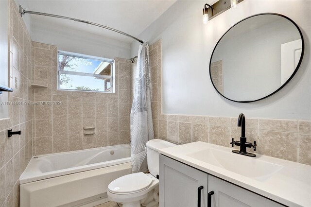 full bathroom featuring shower / bath combo, vanity, toilet, and tile walls