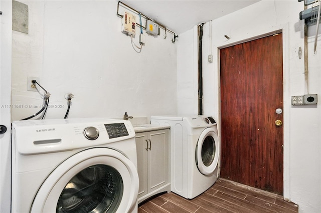 washroom featuring cabinets, separate washer and dryer, dark wood-type flooring, and sink