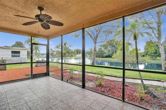 unfurnished sunroom with a water view and ceiling fan