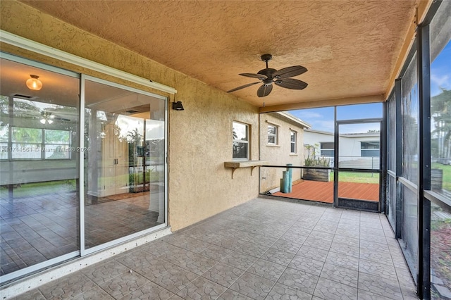 unfurnished sunroom featuring ceiling fan