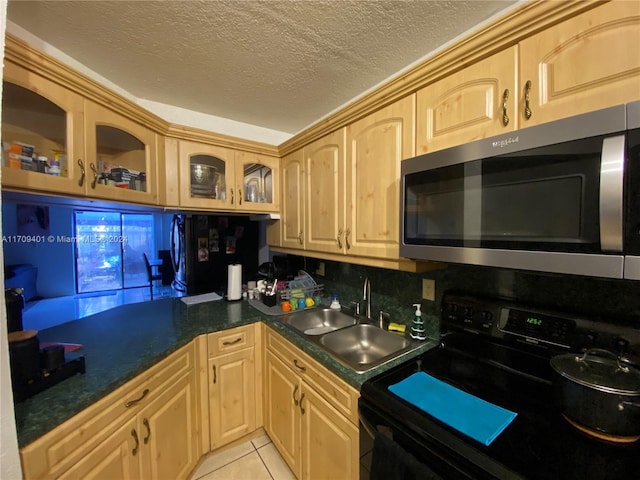 kitchen with sink, light brown cabinets, black / electric stove, a textured ceiling, and light tile patterned floors