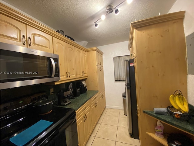 kitchen with light brown cabinetry, light tile patterned floors, stainless steel appliances, and a textured ceiling