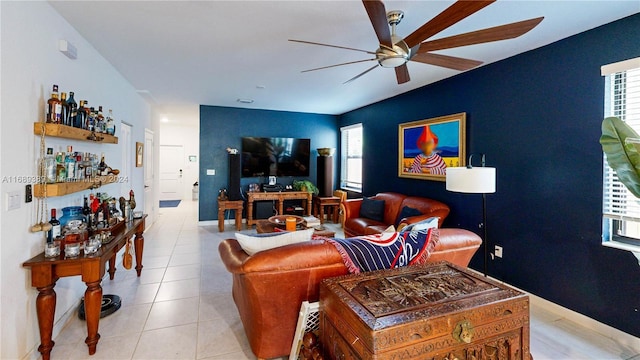 tiled living room featuring bar and ceiling fan