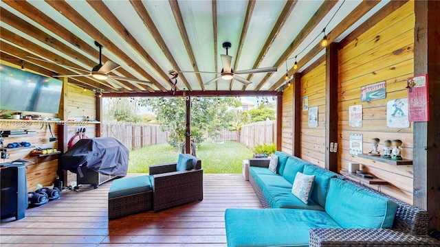 wooden terrace with grilling area, ceiling fan, and an outdoor hangout area