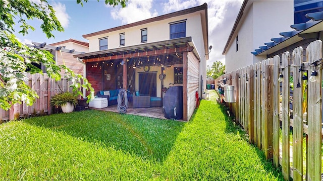 back of house with a lawn, an outdoor living space, and a patio