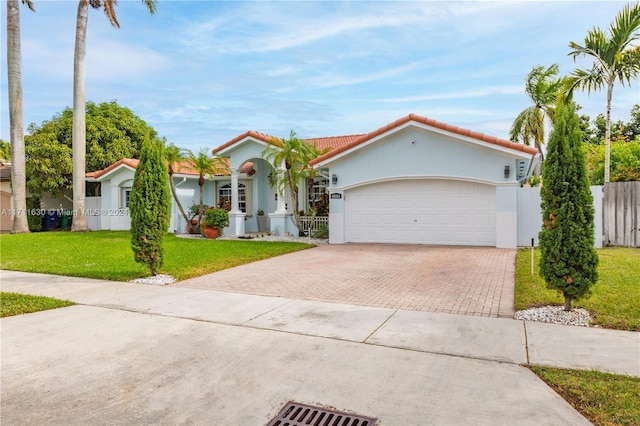 mediterranean / spanish-style home with a garage and a front lawn