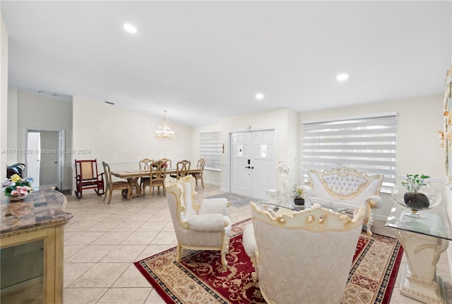 living room with a chandelier, light tile patterned floors, and vaulted ceiling