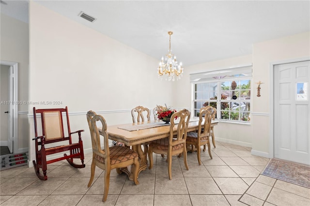 dining space featuring light tile patterned flooring and an inviting chandelier