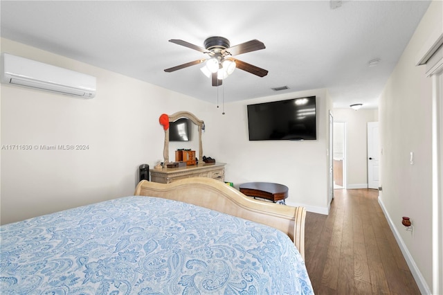 bedroom with a wall unit AC, ceiling fan, and hardwood / wood-style flooring