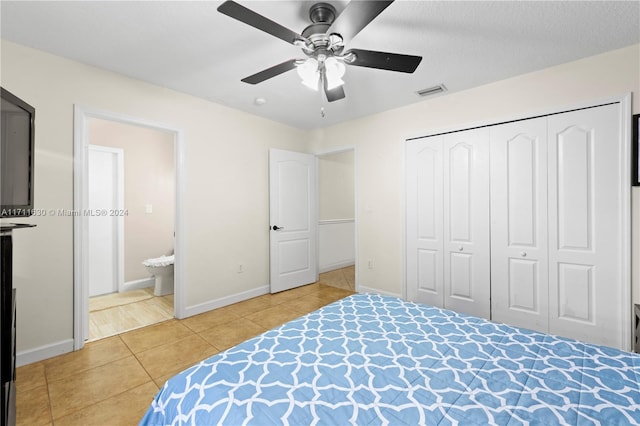 tiled bedroom featuring a textured ceiling, a closet, ensuite bath, and ceiling fan