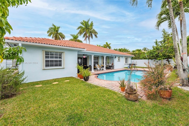 view of swimming pool featuring ceiling fan, a patio area, and a lawn