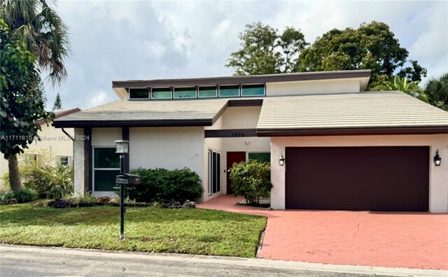 view of front of property featuring a front yard and a garage