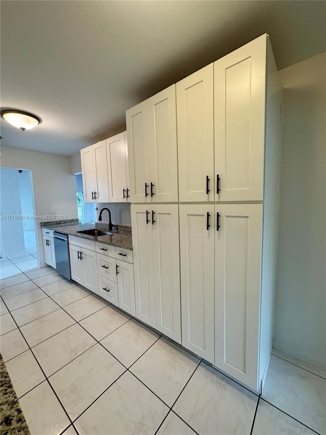 kitchen featuring dark stone counters, sink, white cabinets, and stainless steel dishwasher