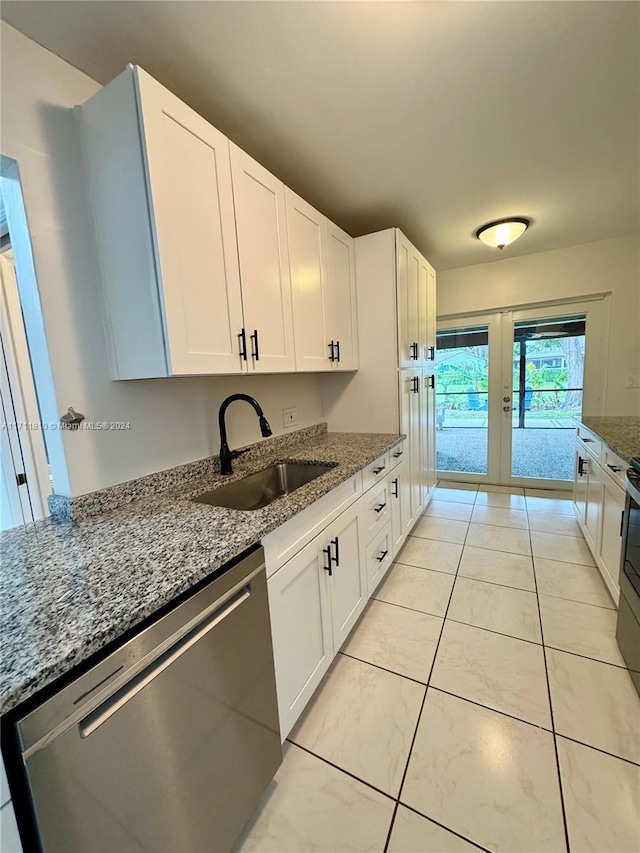 kitchen with dishwasher, white cabinets, sink, light stone countertops, and light tile patterned floors