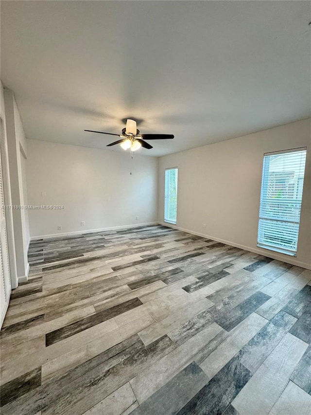 empty room with ceiling fan and light wood-type flooring