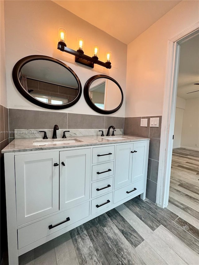 bathroom featuring vanity, hardwood / wood-style flooring, tile walls, and ceiling fan