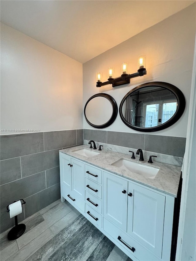 bathroom featuring hardwood / wood-style flooring, vanity, and tile walls