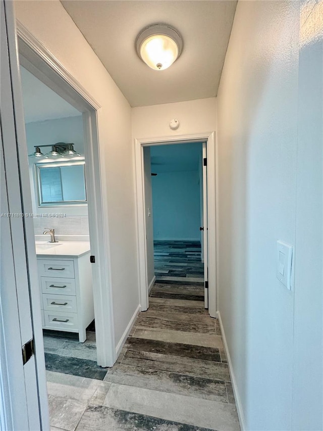 corridor with dark hardwood / wood-style flooring and sink