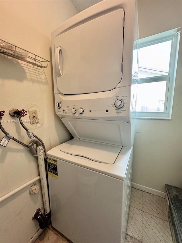 washroom featuring stacked washer and clothes dryer