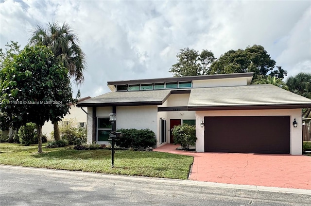 view of front of home with a garage and a front lawn