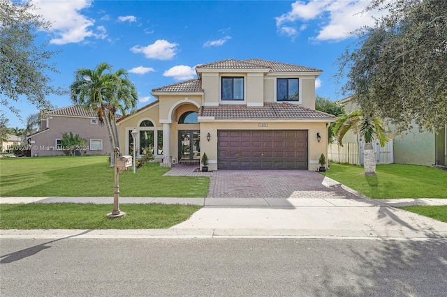 mediterranean / spanish house featuring a front yard and a garage