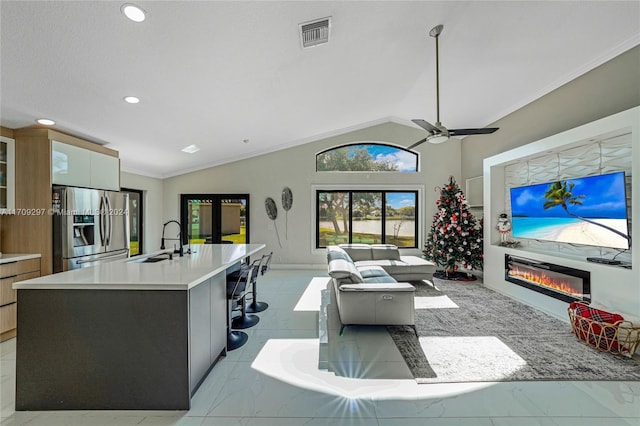 living room featuring lofted ceiling, french doors, crown molding, sink, and ceiling fan