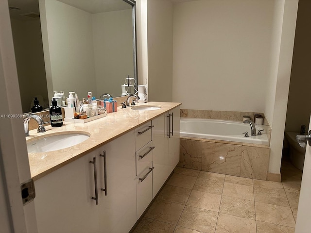 bathroom featuring vanity and tiled bath