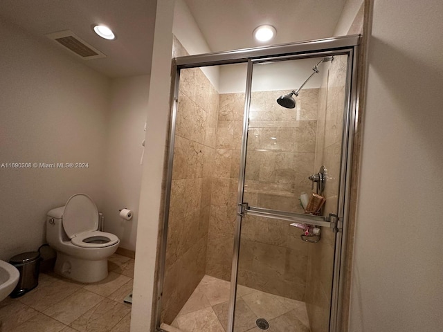 bathroom featuring walk in shower, tile patterned floors, and toilet