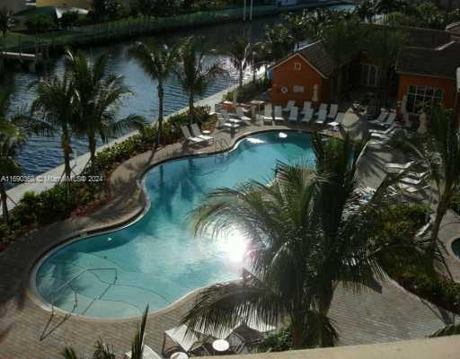 view of pool with a water view and a patio