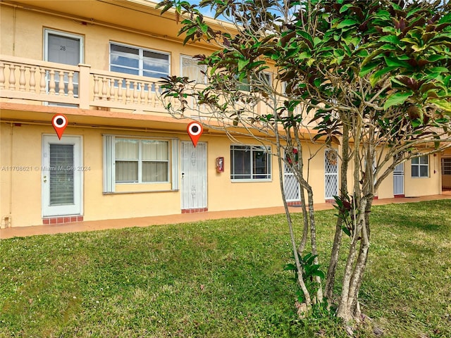 view of front of home featuring a balcony and a front yard