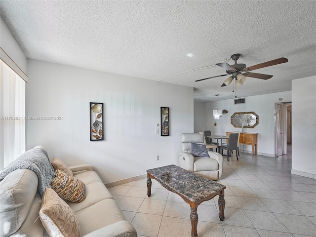 tiled living room with ceiling fan and a textured ceiling