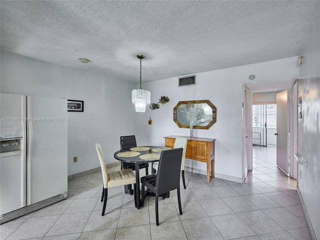 tiled dining room featuring a textured ceiling