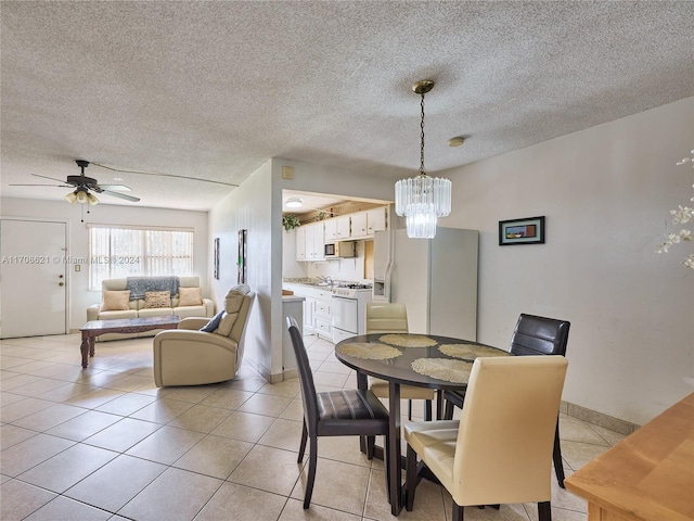 tiled dining room with a textured ceiling, ceiling fan, and sink