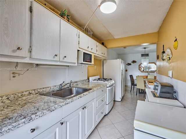 kitchen with a textured ceiling, sink, white cabinets, and white appliances