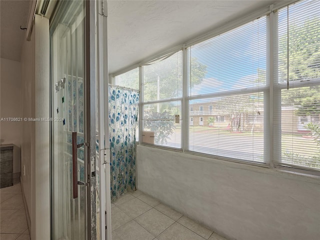 bathroom with tile patterned floors and walk in shower