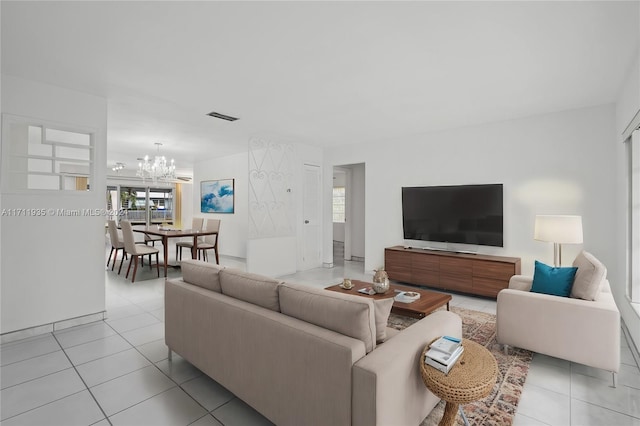 tiled living room featuring a wealth of natural light and an inviting chandelier