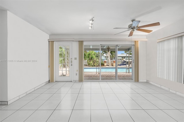 tiled empty room featuring plenty of natural light and ceiling fan